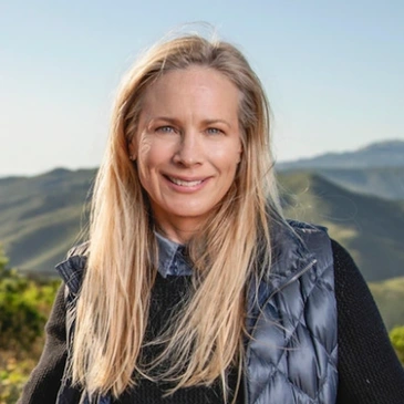 A woman standing in front of some mountains