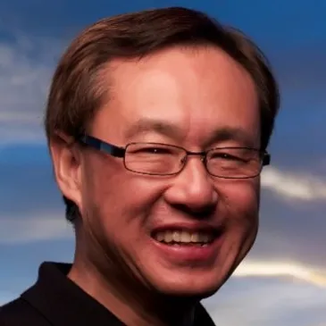 A man with glasses smiling for the camera.