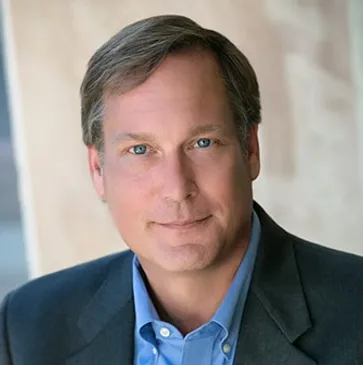 A man in a suit and blue shirt.